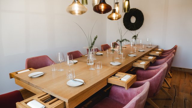 Hirschenblobb: unsere Bar Moderner Esstisch mit rosa Stühlen und hängenden Lampen für acht Personen