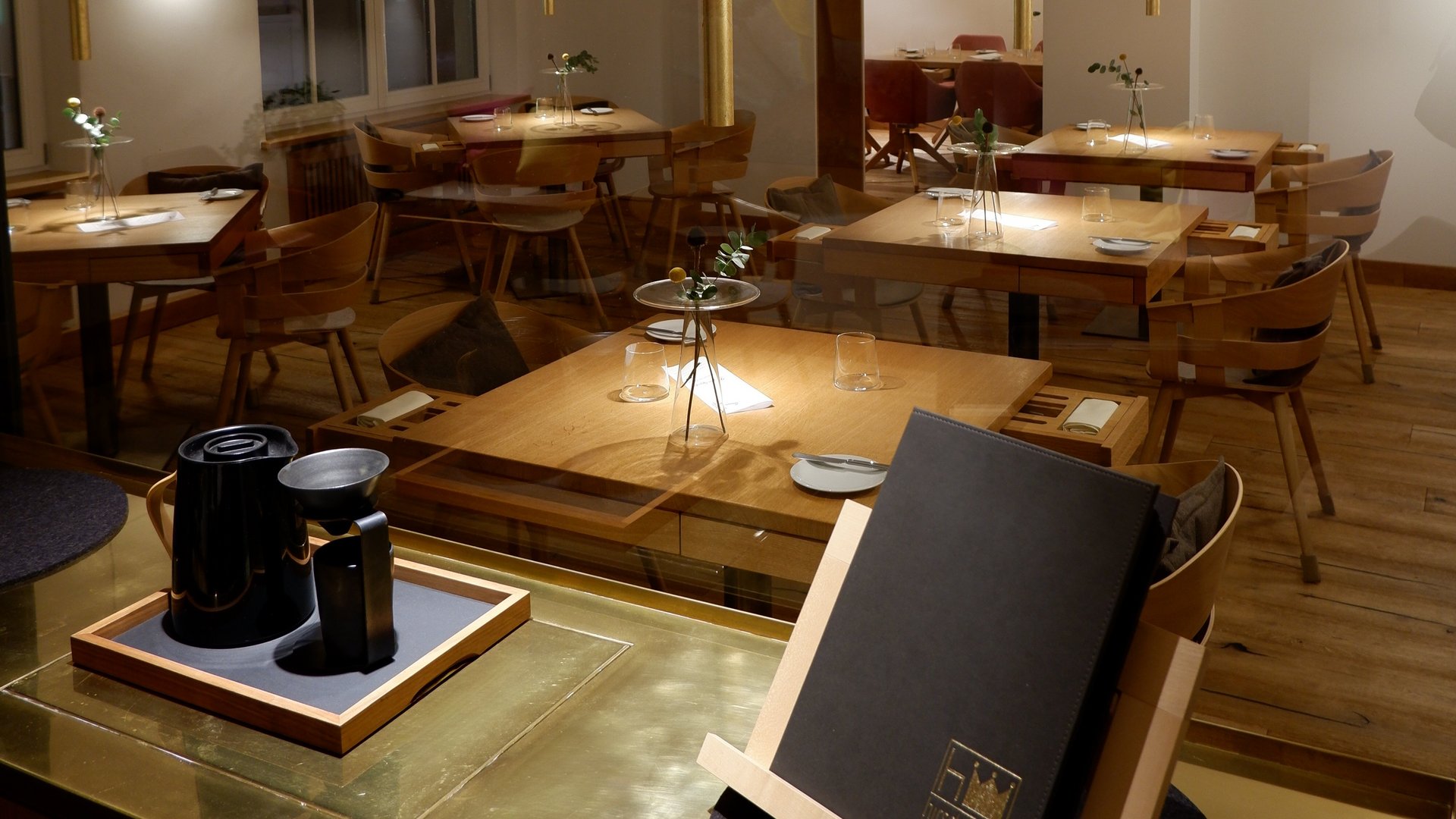 Restaurant in Parsberg: Gourmet genießen Modernes Restaurant mit Holzmöbeln und gedeckten Tischen bei gedämpftem Licht