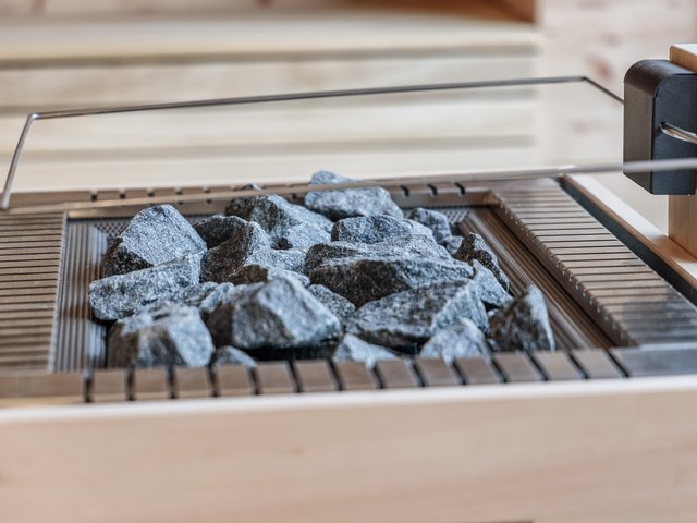 Romantik Hotel Hirschen: Bildergalerie Saunaofen mit heißen Sauna-Steinen in einer Holzsauna