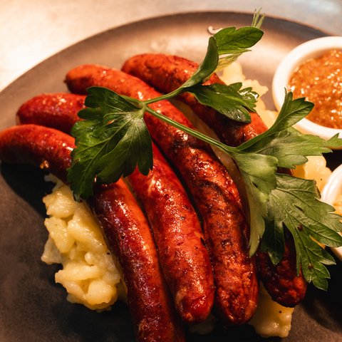 Gasthof & Restaurant in Parsberg mit regionaler Küche Gegrillte Würstchen mit Reis, Petersilie und zwei Dips auf einem Teller