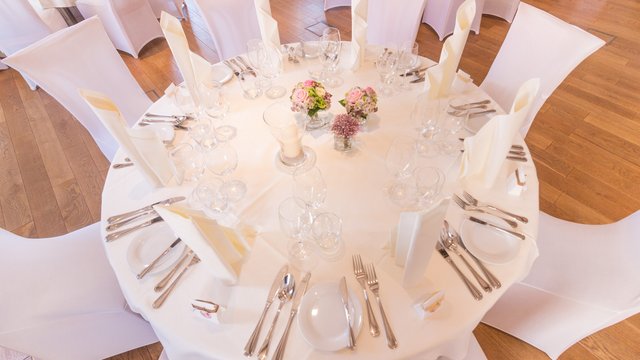 Romantik Hotel Hirschen: Blog Festlich gedeckter runder Tisch mit weißen Stühlen, Blumen und Servietten