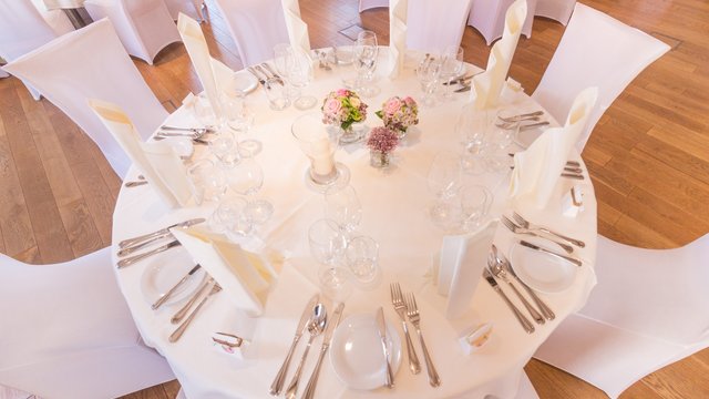 Romantik Hotel Hirschen: Blog Festlich gedeckter runder Tisch mit weißen Stühlen, Blumen und Servietten
