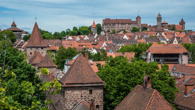 Romantik Hotel Hirschen: Blog Blick auf Nürnbergs Altstadt mit Burg und roten Ziegeldächern unter bewölktem Himmel